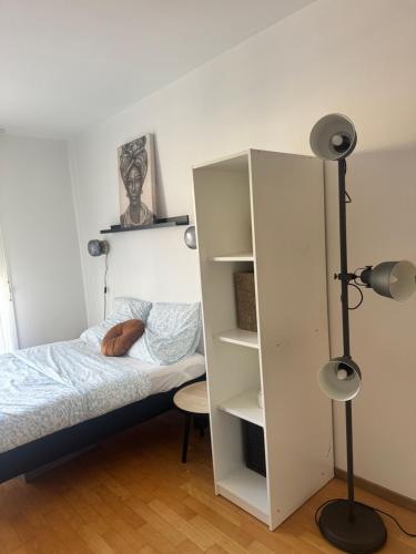 a bedroom with a bed and a white cabinet at Le Beau Coin de Paris in Soisy-sous-Montmorency