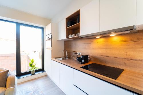 a kitchen with white cabinets and a wooden counter top at Fourstay Luxury City Apartments Diegem - Brussels in Diegem