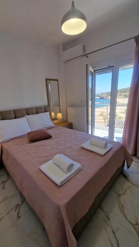 a bedroom with a large bed with two towels on it at Aegean Horizon Apartment in Skala Marion