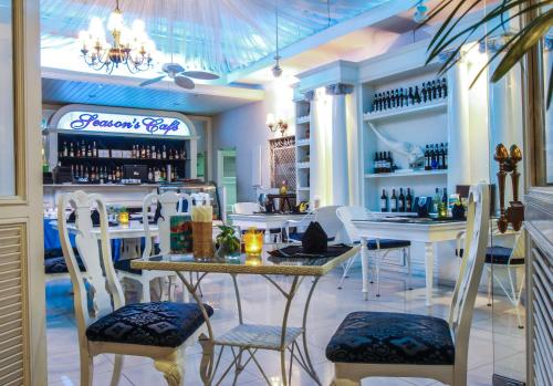 a restaurant with a bar with white tables and chairs at Four Seasons Place Pattaya in Pattaya