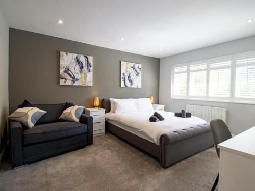 un dormitorio con una cama y un sofá en The Bar Bubbles Retreat - Hot Tub Games Room Pass the Keys, en Hastings