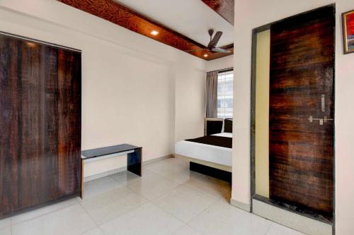 a room with a bedroom with a bed and a window at Collection O Chakan MIDC Pune in Pune