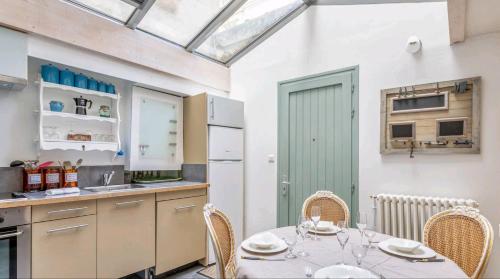 une cuisine avec une table et des chaises dans une cuisine dans l'établissement L'atypique, au centre ville pour 4 à 5 personnes, à La Rochelle