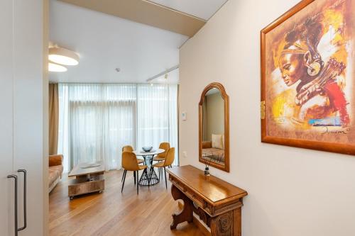 a living room with a table and a painting on the wall at Sun Sonata Apartments 3 in Druskininkai