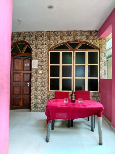 a red table in a room with a window at Arambol Residensea in Pernem