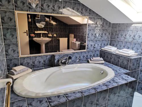 a bathroom with a tub and a sink and a mirror at Appartement Vue Mer à Bastia, terrasse et piscine privée. in Bastia