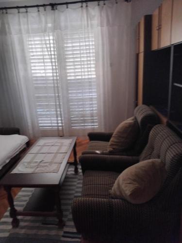 Una sala de estar con dos sillas y una mesa. en Apartman Mokri Dolovi, en Trebinje
