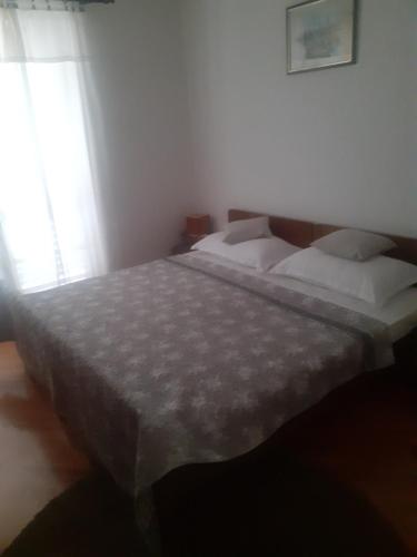 Un dormitorio con dos camas y una ventana en Apartman Mokri Dolovi, en Trebinje