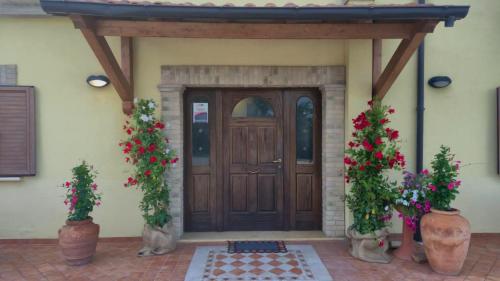 a front door of a house with two potted plants at Agriturismo San Silvestro in Piazzano