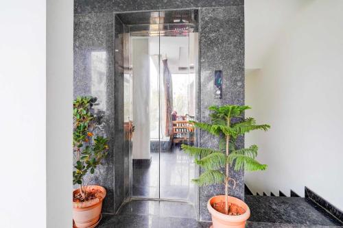 a hallway with potted plants on the floor at Hotel O Banaswadi in Bengaluru