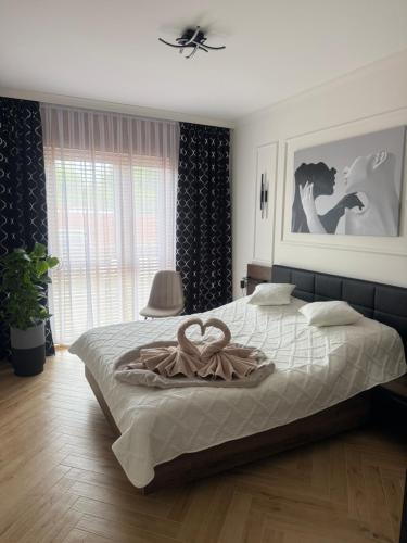 a bedroom with a bed with a heart towel on it at Apartament Anna De Lux z dużym tarasem in Zamość