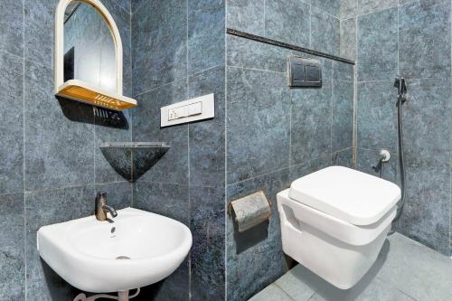 a bathroom with a sink and a toilet and a mirror at Hotel O Banaswadi in Bengaluru