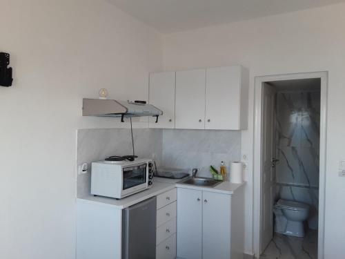 a small kitchen with a microwave and a sink at studio 1 Georgina in Mourteri