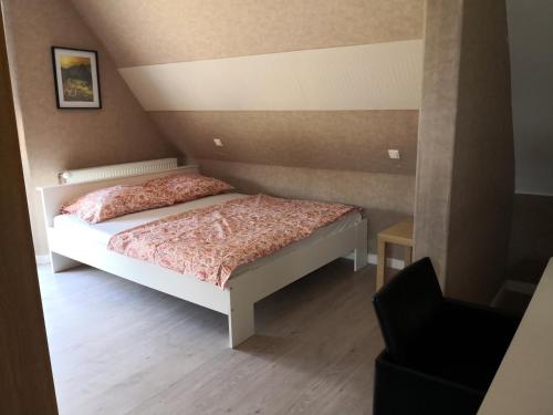 a small bedroom with a bed and a chair at Chambre Chez l'habitant in Seltz