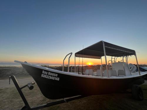 a boat parked on the beach with the sunset in the background at Puerto San Carlos Bay House & Tours -2nd Floor- in San Carlos
