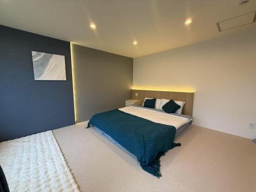 a bedroom with a bed and a painting on the wall at アロハ鎌倉 in Kamakura