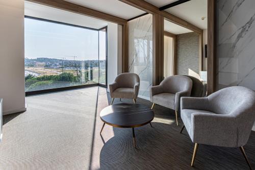 a waiting room with chairs and a table and a large window at Hotel Inffinit Sanxenxo in Sanxenxo