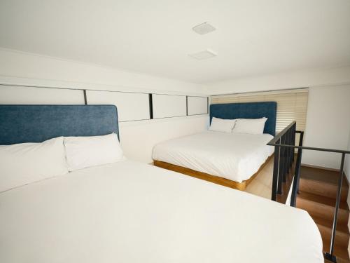 two beds in a small room with a balcony at UH FLAT Signature GANGNAM in Seoul