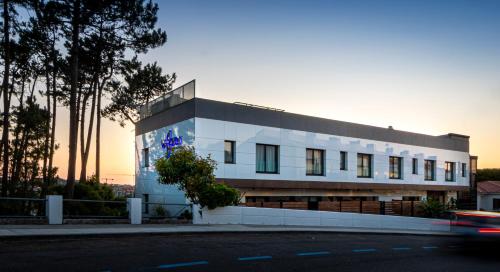 a white building on the side of a street at Hotel Inffinit Sanxenxo in Sanxenxo
