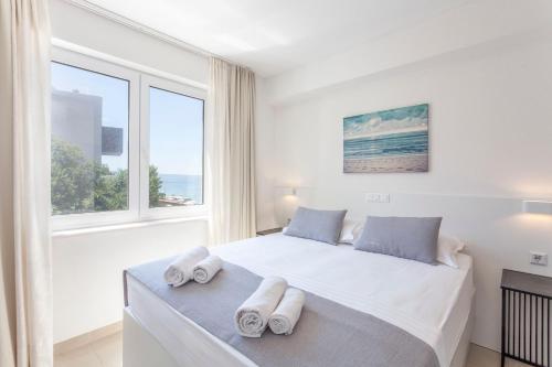 a bedroom with a large bed with towels on it at Sunset Split Rooms in Podstrana