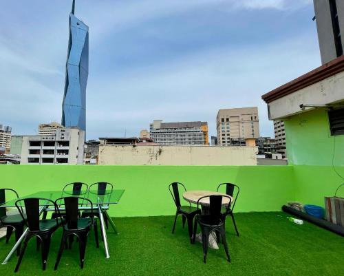 a group of tables and chairs on a green wall at The Explorers Guesthouse and Hostel in Kuala Lumpur