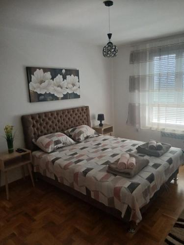 a bedroom with a large bed with towels on it at Apartman Petra in Niš