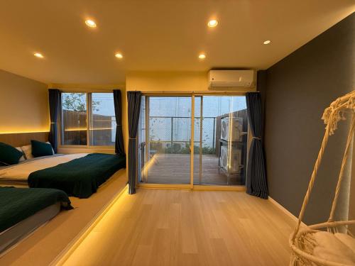 a bedroom with two beds and a balcony at アロハ鎌倉 in Kamakura