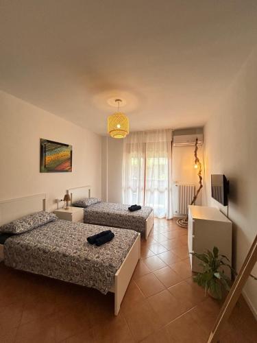 a room with three beds and a television in it at BeLù Home Rho Fiera in Rho