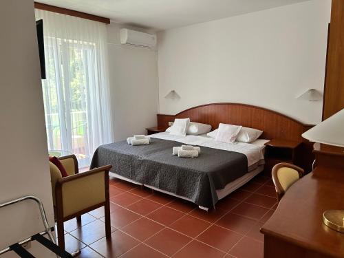 a bedroom with a bed with two towels on it at Guest House Sol in Cavtat