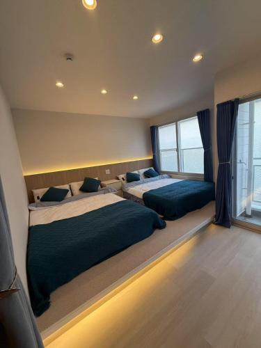a bedroom with two beds and a large window at アロハ鎌倉 in Kamakura