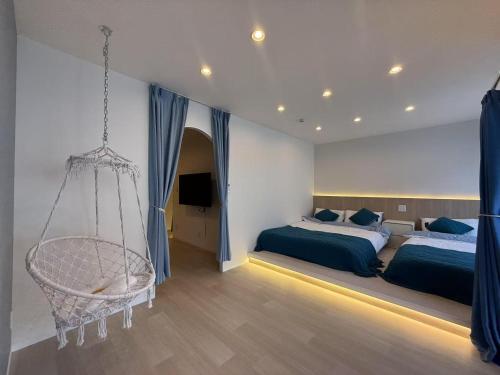 a bedroom with two beds and a swing at アロハ鎌倉 in Kamakura