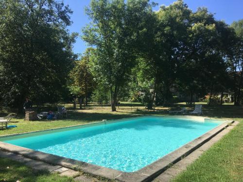 Cambounet-sur-le-SorChâteau Belle au Bois Dormant的一座绿树成荫的庭院中的蓝色游泳池