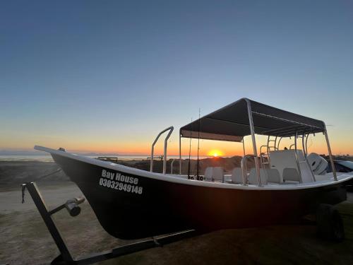 a boat parked on the beach with the sunset at Puerto San Carlos Bay House & Tours -1st & 2nd Floor- in San Carlos