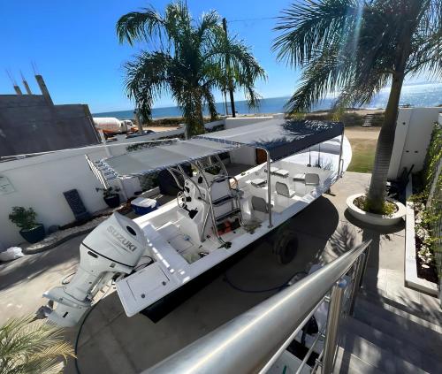 a boat on the side of a building with palm trees at Puerto San Carlos Bay House & Tours -1st & 2nd Floor- in San Carlos