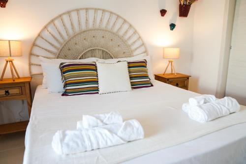 a bedroom with a large white bed with towels on it at Fraledune in Maruggio