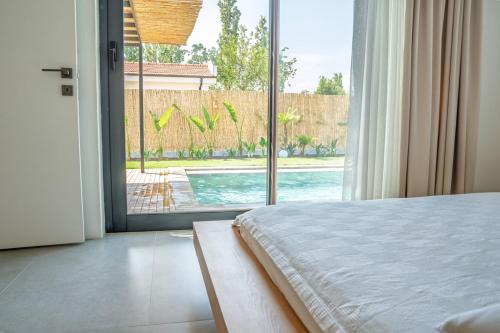 a bedroom with a large window with a view of a pool at Vacation - Honeymoon House in Ortaca