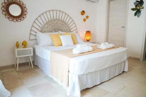 a bedroom with a large white bed with towels on it at Fraledune in Maruggio
