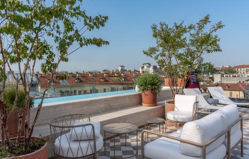 a group of chairs and tables on a roof at Hotel Calimala Milano in Milan