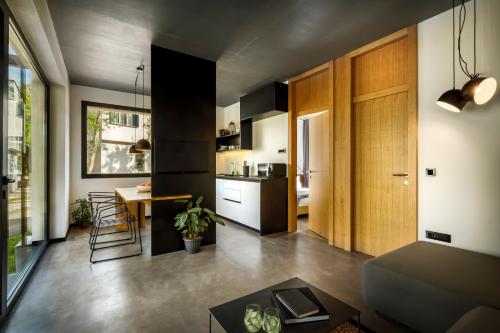 a living room with a table and a kitchen at Aminess Younique Gaia Green Villas in Njivice