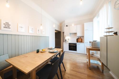 a kitchen and dining room with a wooden table and chairs at Blue flat by GrazRentals best location & free parking in Graz