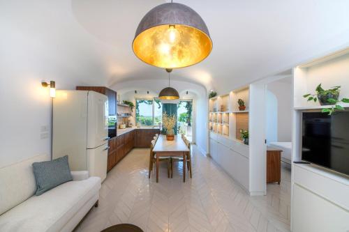 a kitchen and living room with a table and a couch at OraBlu Exclusive Villas in Ischia