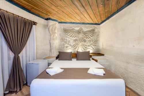 a bedroom with two beds and an eagle on the wall at Kayatas Cave Suites in Goreme