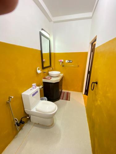 a bathroom with a toilet and a sink at Coco Palm Villa and Cabanas in Tangalle
