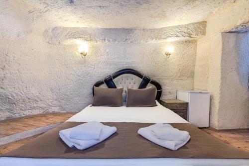a bedroom with a bed with two pillows on it at Kayatas Cave Suites in Goreme