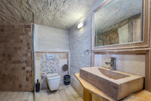 a bathroom with a sink and a toilet at Kayatas Cave Suites in Goreme
