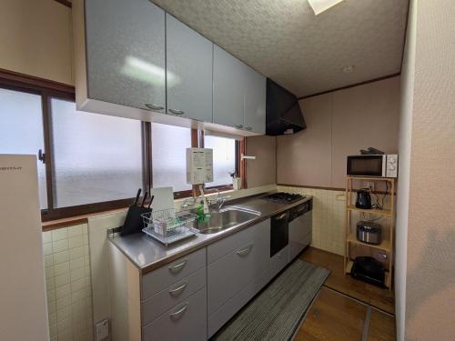 a small kitchen with a sink and a stove at Taketori Roten -House with open-air bath in Beppu