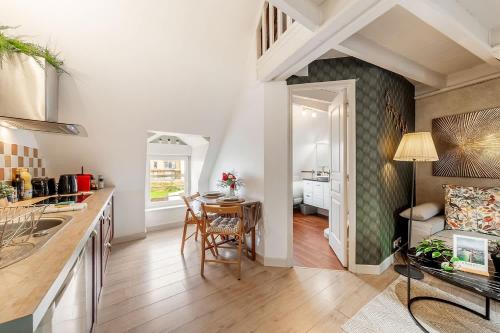 una cucina e un soggiorno con tavolo e sedie di Le Ruellan charmant duplex proche plage a Saint Malo