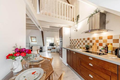 una cucina con un tavolo e una sala da pranzo di Le Ruellan charmant duplex proche plage a Saint Malo
