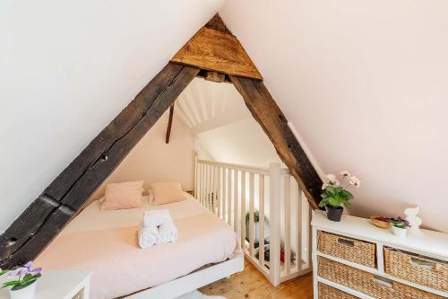 une chambre avec un lit dans un grenier dans l'établissement Le Ruellan charmant duplex proche plage, à Saint-Malo