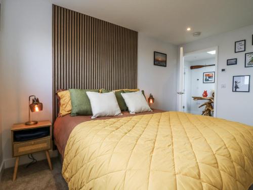 a bedroom with a large bed with a yellow blanket at Flat 4 - Penthouse in Hythe